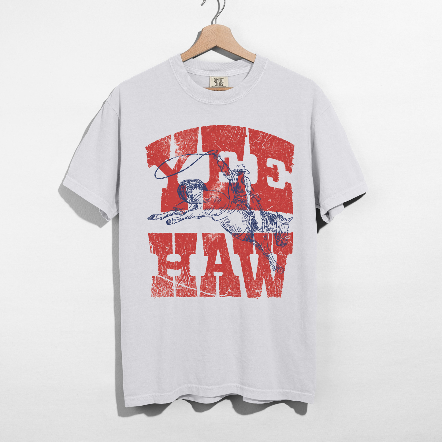 White western graphic tee with red Yee Haw text and cowboy illustration on hanger