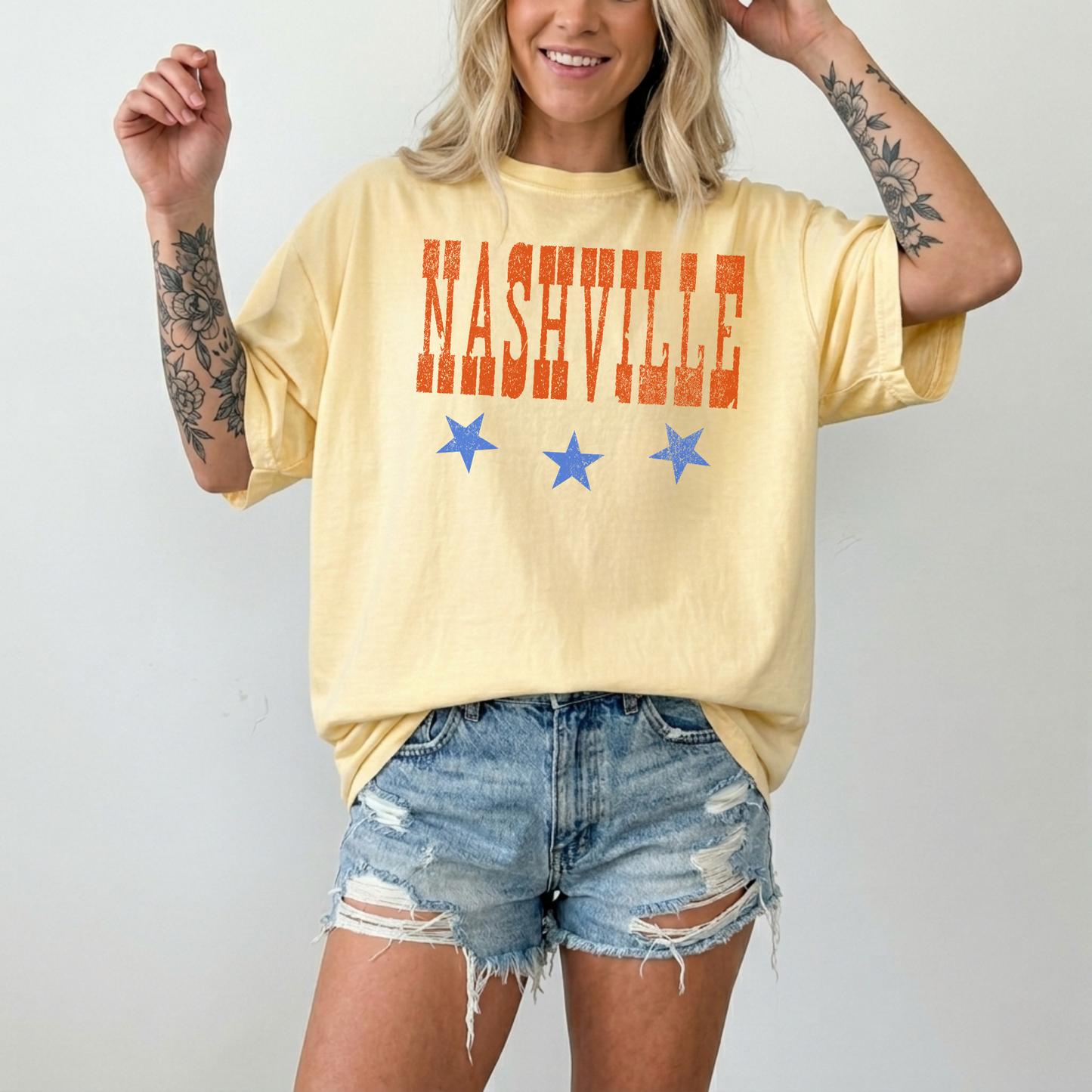 Woman wearing butter yellow Nashville graphic t-shirt with distressed lettering and stars casual summer outfit