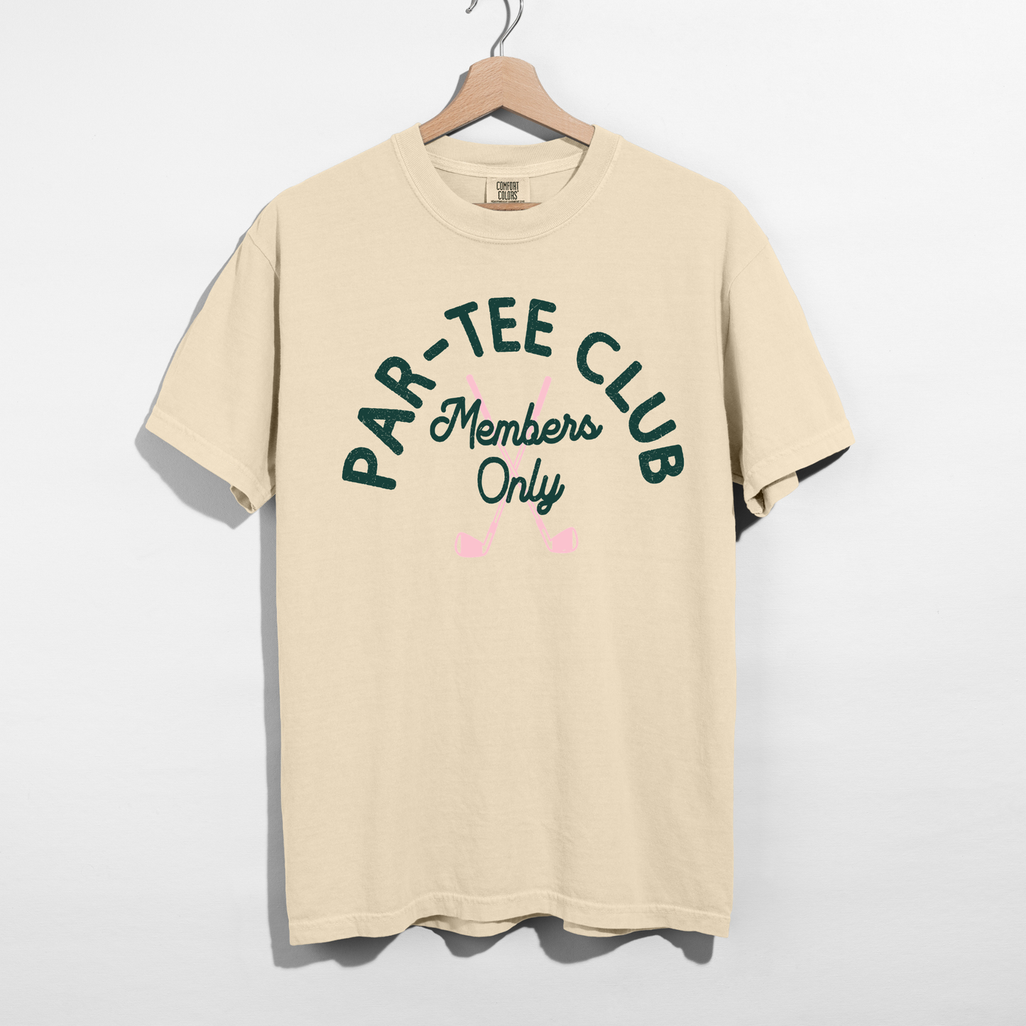 Ivory Par-Tee Club Members Only graphic tee with green distressed lettering and pink golf clubs displayed on a hanger.