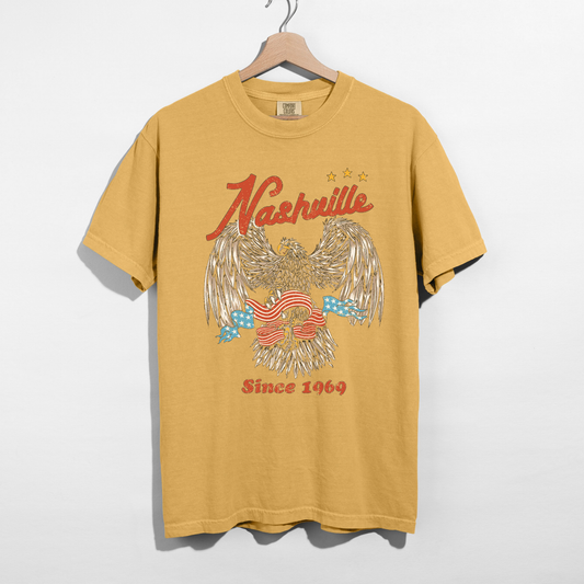 Mustard Nashville graphic t-shirt with vintage eagle design hanging on hanger retro country shirt
