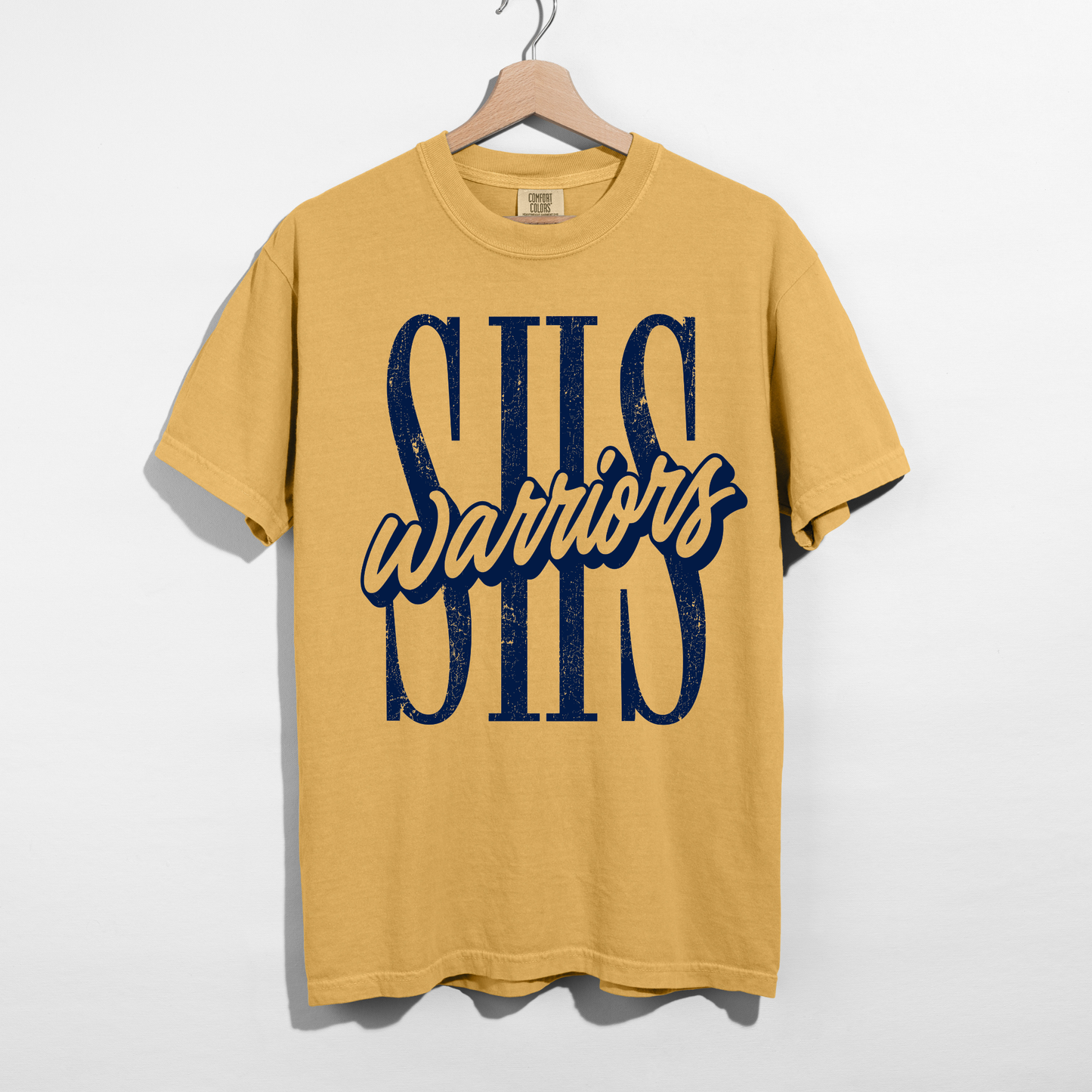 Mustard Sterling Warriors SHS graphic t-shirt featuring oversized distressed navy SHS lettering with script Warriors displayed on a hanger.