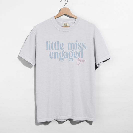 White Little Miss Engaged Est. 2026 engagement t-shirt flat lay
