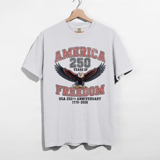 White America 250 Years of Freedom USA 250th Anniversary 1776–2026 graphic tee with vintage eagle design hanging on wooden hanger.