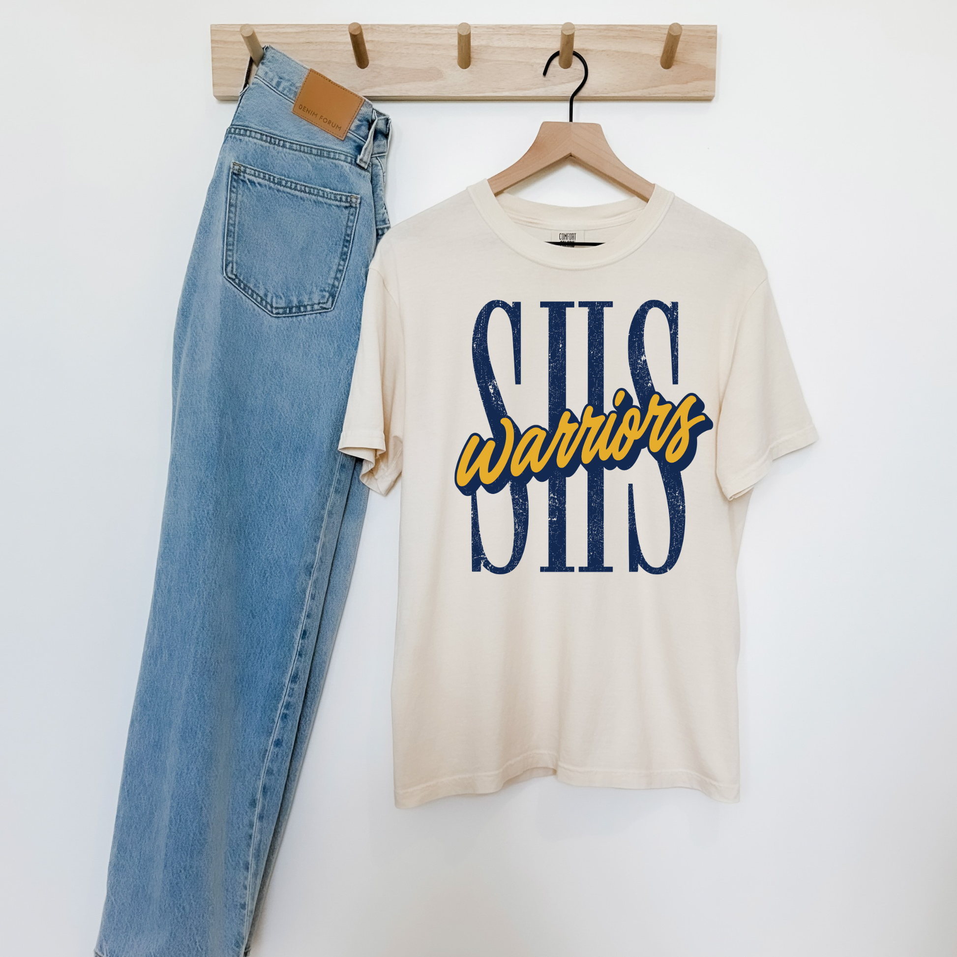 Ivory SHS Warriors graphic t-shirt with distressed navy SHS lettering and gold Warriors script, paired with light wash denim.