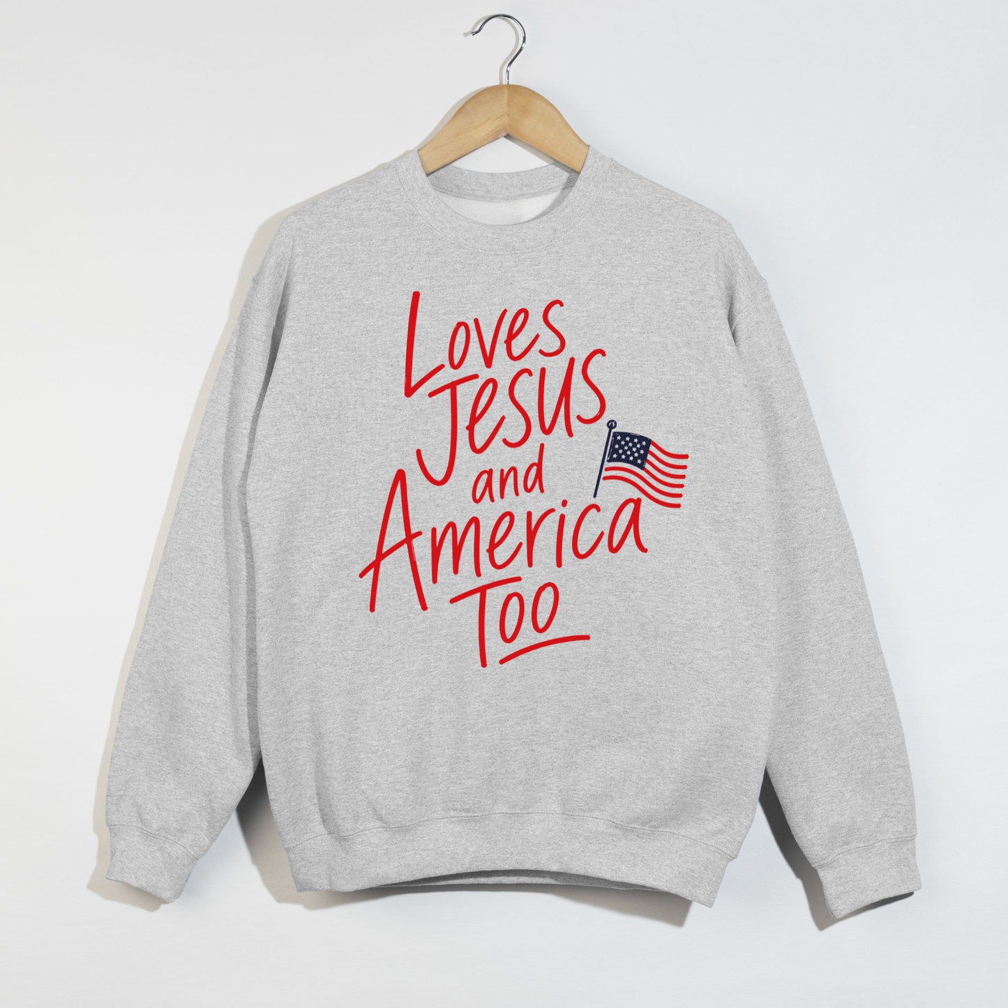 Loves Jesus and America Too faith based patriotic sweatshirt with American flag graphic on ash grey crewneck sweatshirt