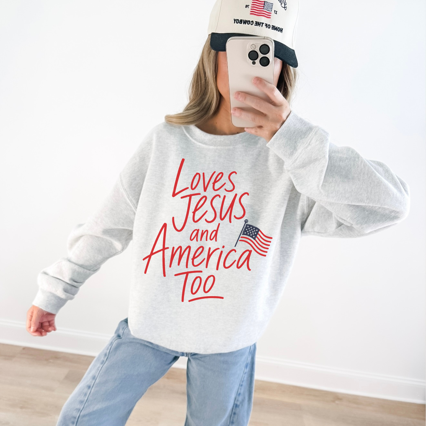 Woman wearing Loves Jesus and America Too patriotic Christian sweatshirt with American flag graphic and casual Americana style outfit