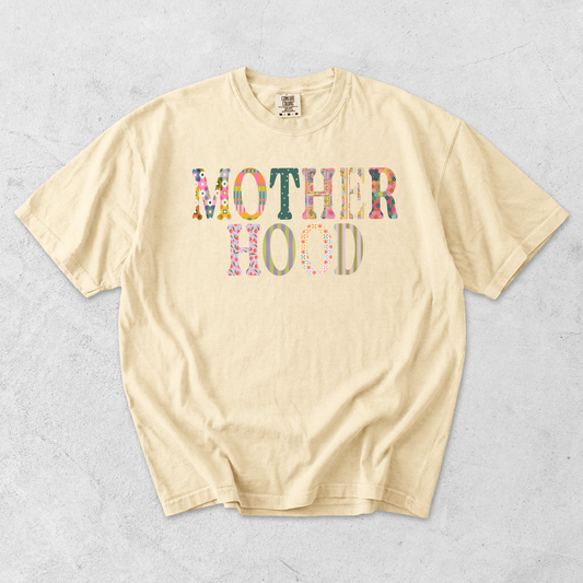 Butter yellow Comfort Colors motherhood graphic tee featuring colorful floral and striped patchwork lettering.