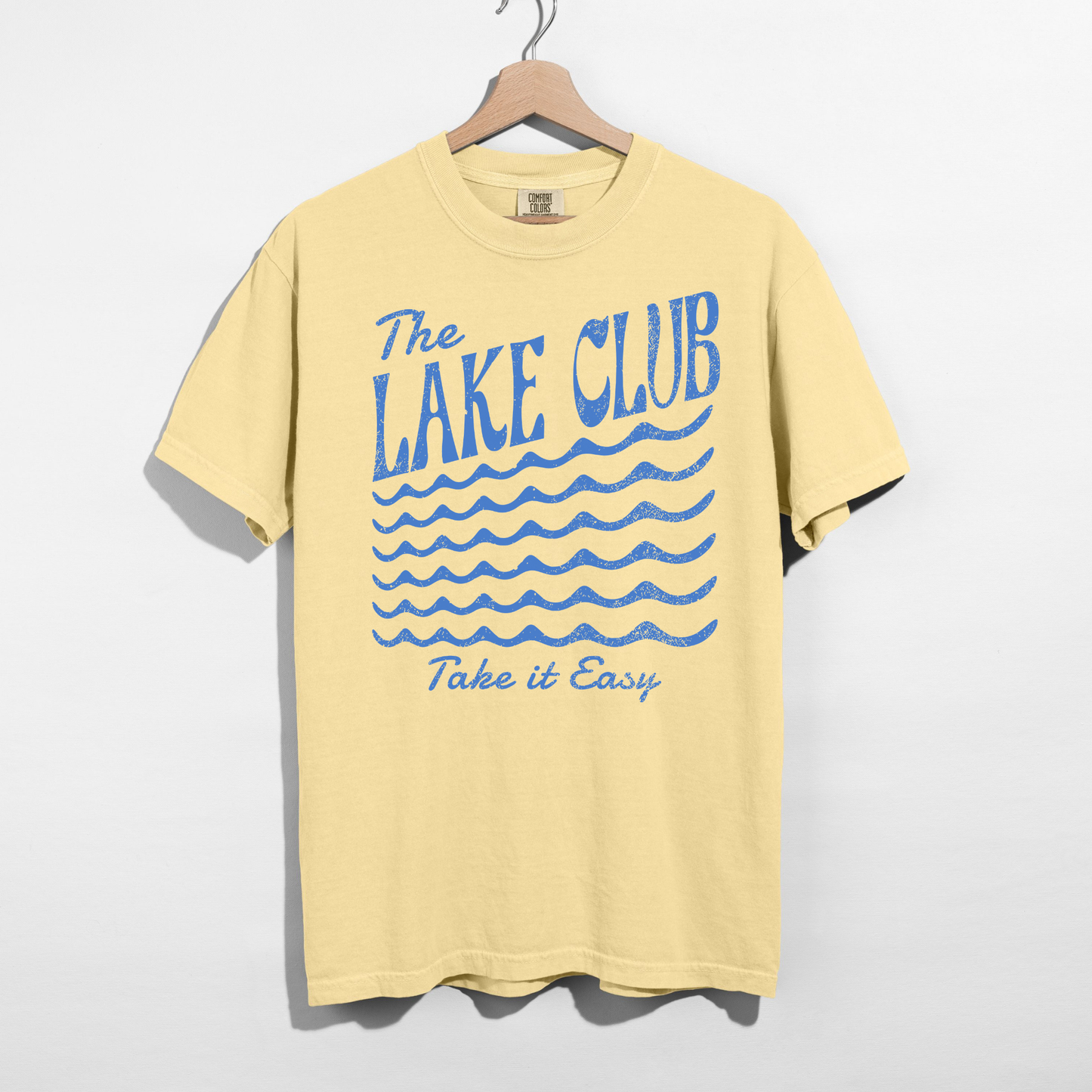 Butter yellow Comfort Colors t-shirt featuring The Lake Club Take It Easy distressed blue lake graphic and wave design