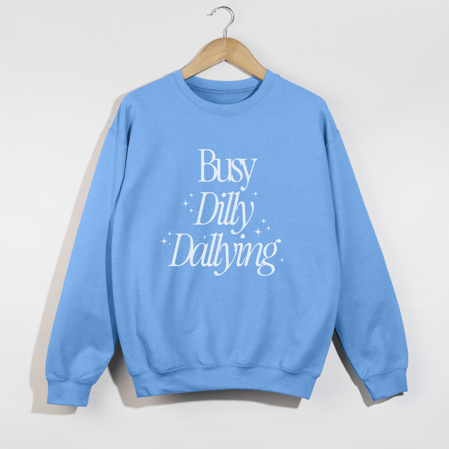 Blue sweatshirt with 'Busy Dilly Dallying' text on a hanger against a white background