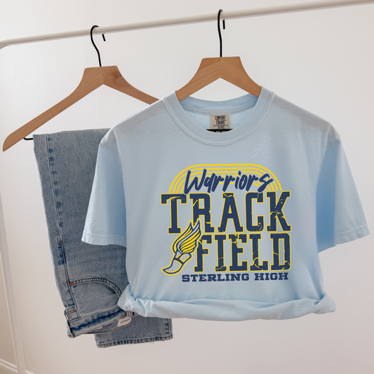 Light blue t-shirt with 'Warriors Track Field Sterling High' design on a hanger against a white background.