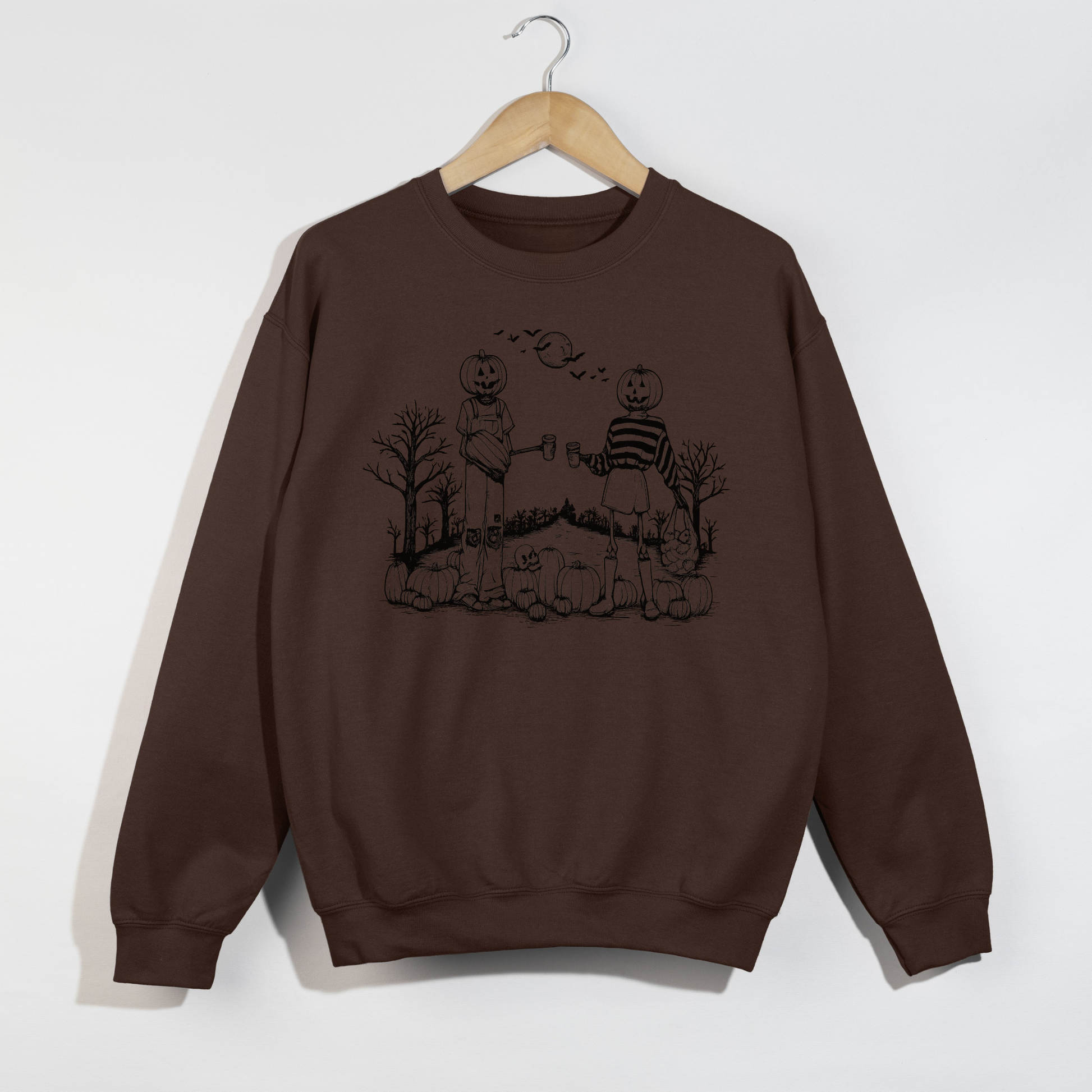 Chocolate brown Halloween crewneck sweatshirt featuring a vintage pumpkin friends graphic with pumpkins, spooky trees, bats, and a cozy autumn aesthetic.