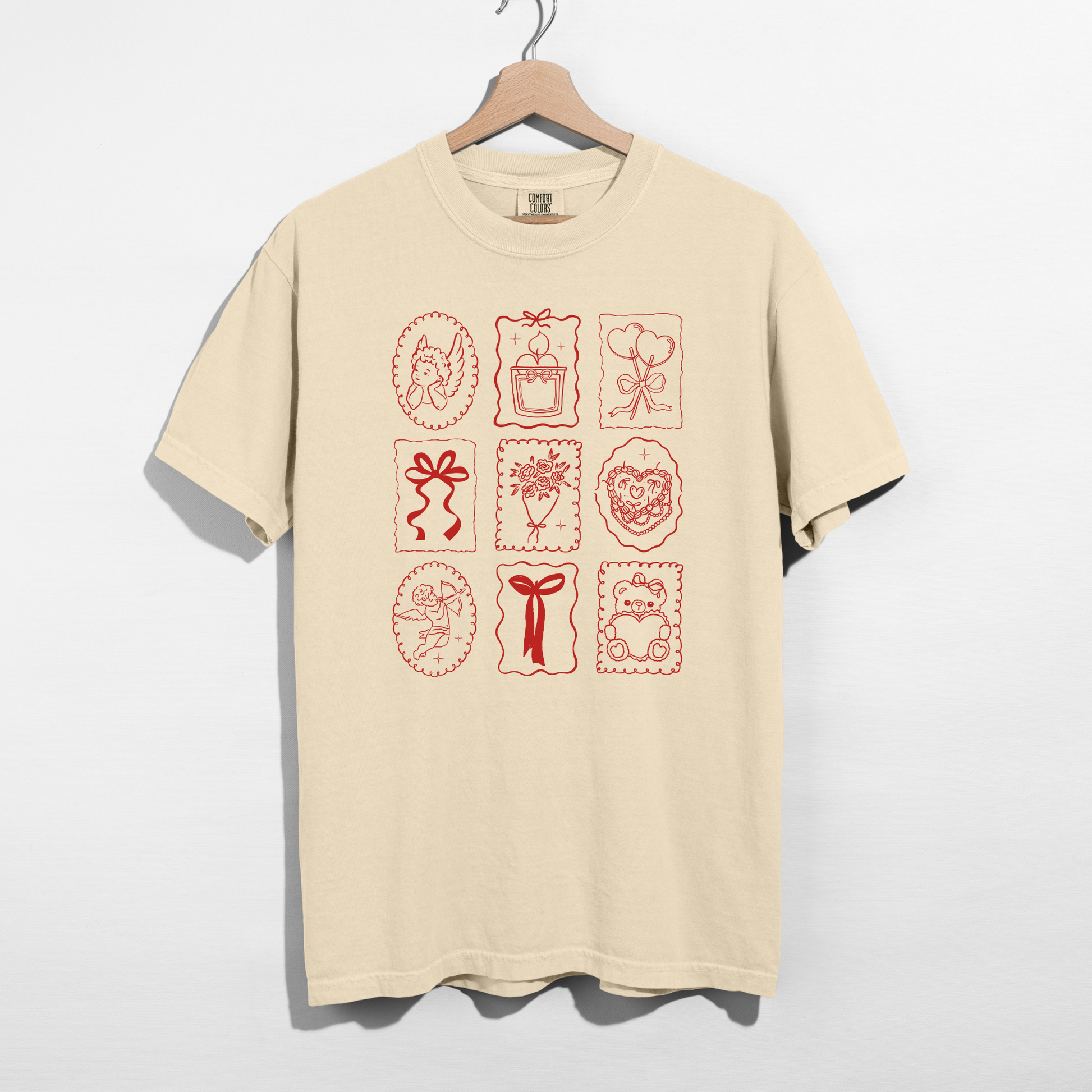 Ivory Comfort Colors tee with red Valentine stamp icons graphic on hanger.