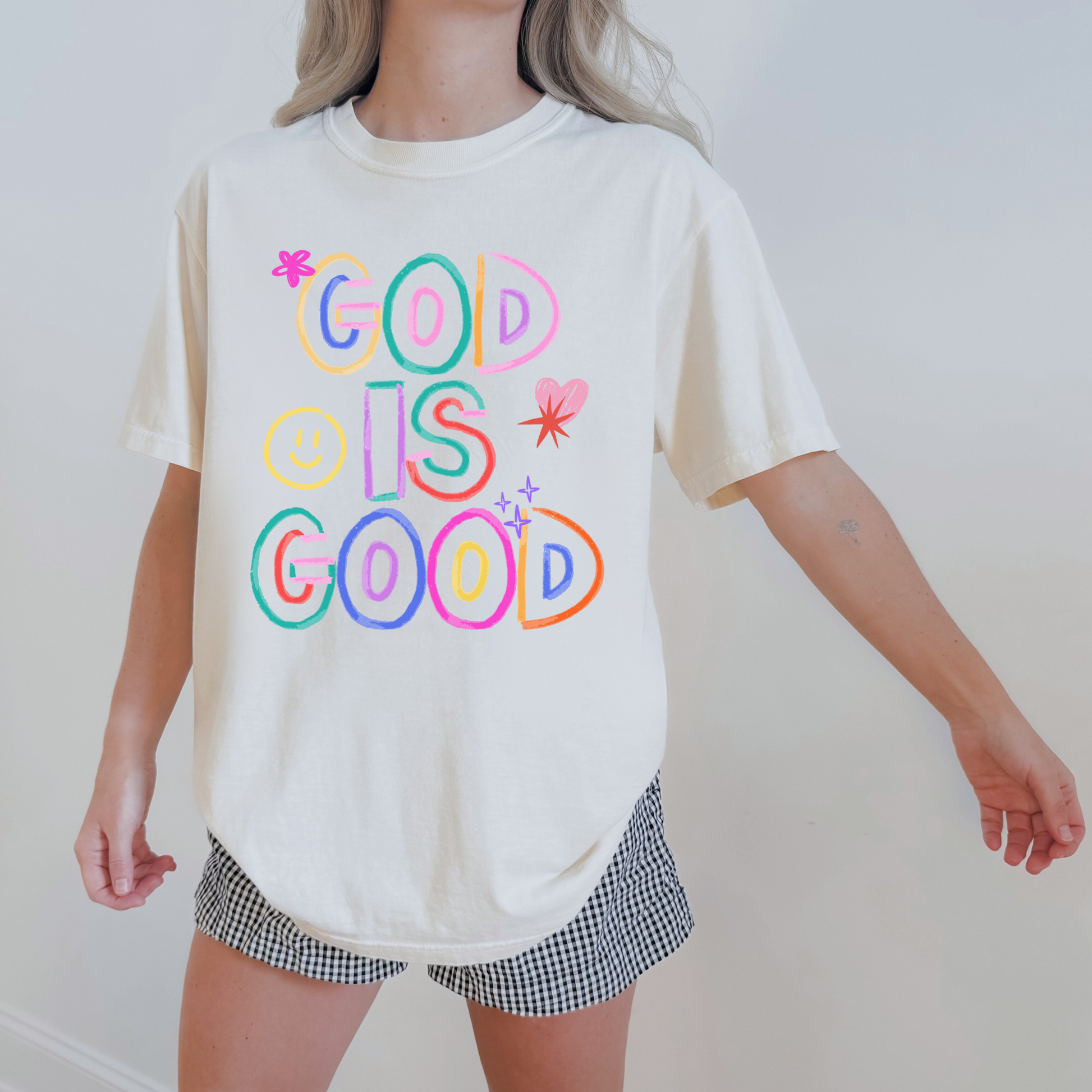 Woman wearing God Is Good graphic tee styled casually