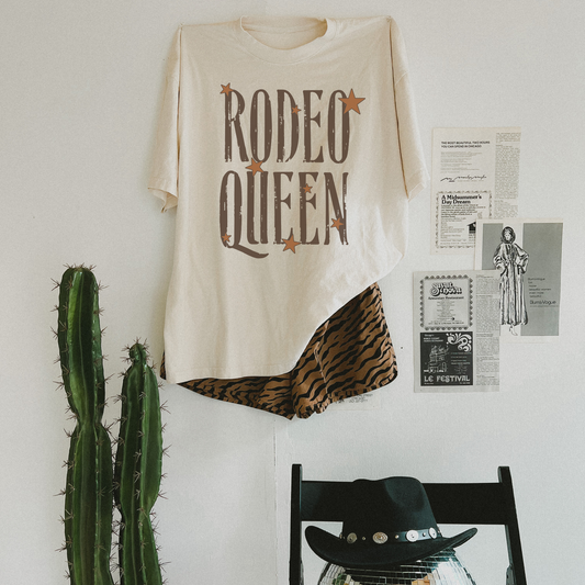 Rodeo Queen graphic tee flat lay styled with western decor and patterned shorts