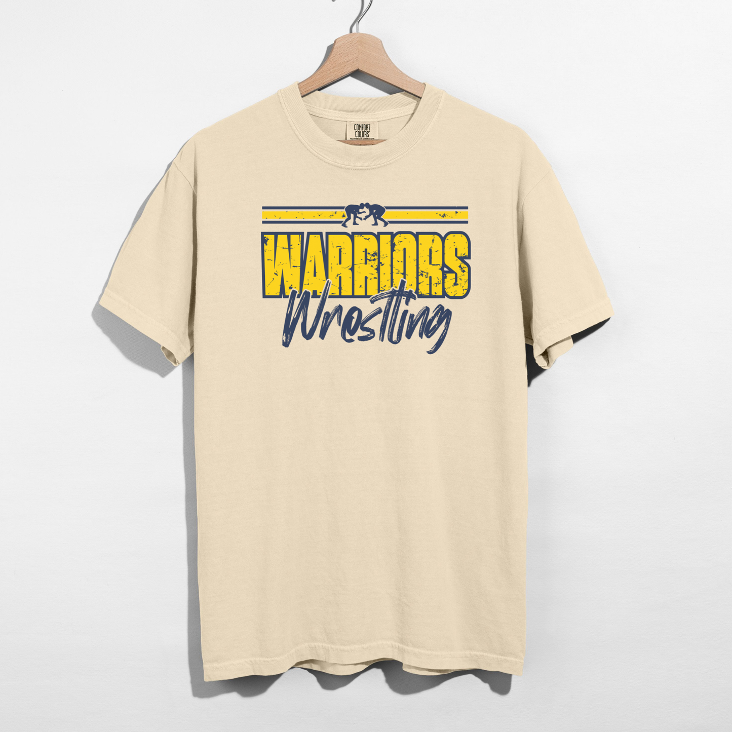 Beige t-shirt with 'Warriors Wrestling' text on a hanger against a white background