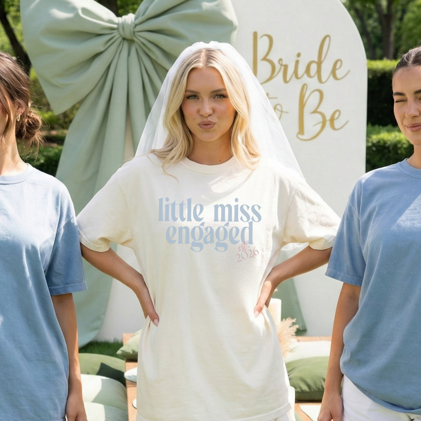 Bride wearing ivory Little Miss Engaged Est. 2026 t-shirt at outdoor engagement party