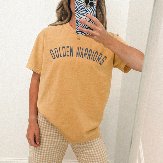 Person wearing a mustard yellow 'Golden Warriors' t-shirt and plaid pants.