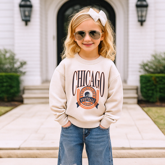Child wearing a 'Chicago' sweatshirt and sunglasses in front of a house.