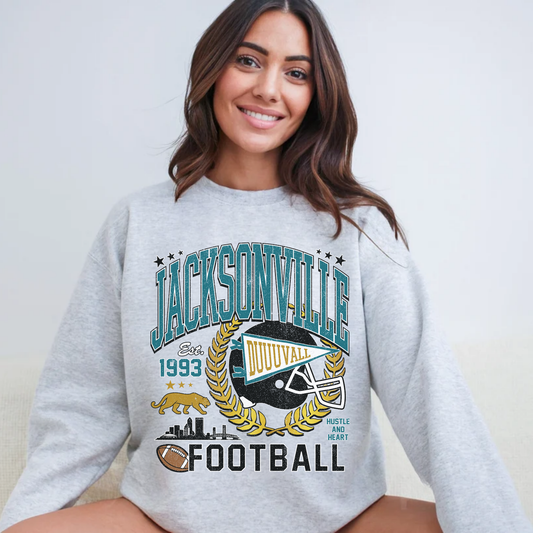 Woman wearing Jacksonville football graphic crewneck sweatshirt with teal gold Duval game day design