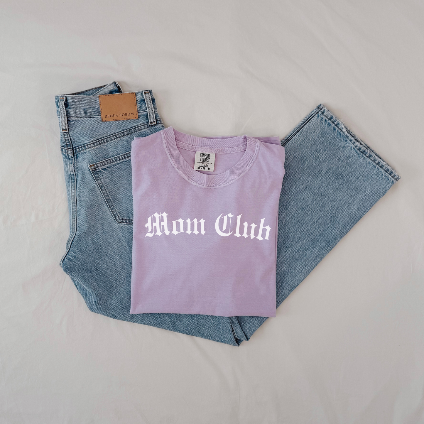 Flat lay of Mom Club Comfort Colors t-shirt showing vintage wash fabric