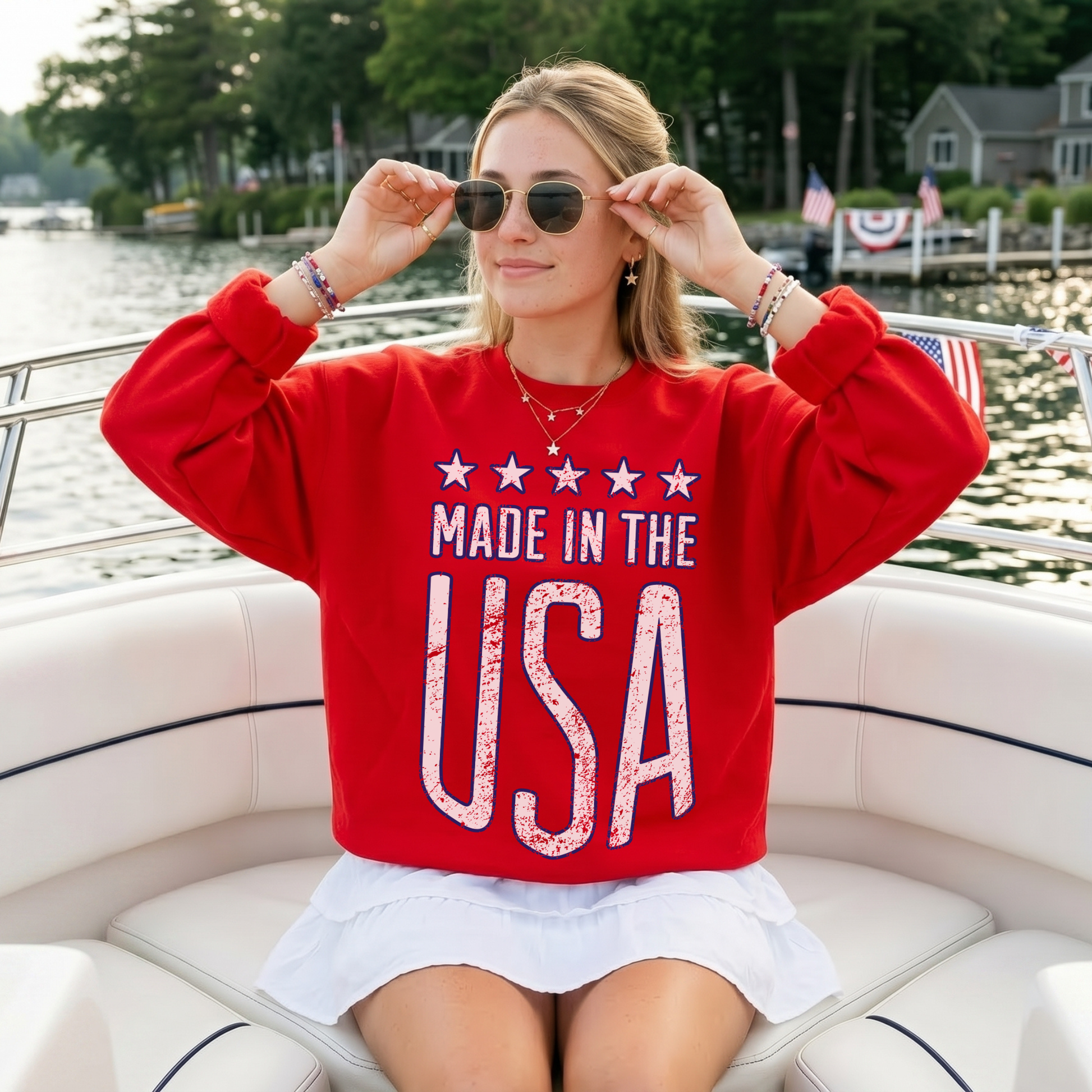 Woman wearing red Made in the USA sweatshirt on a boat with sunglasses patriotic summer outfit