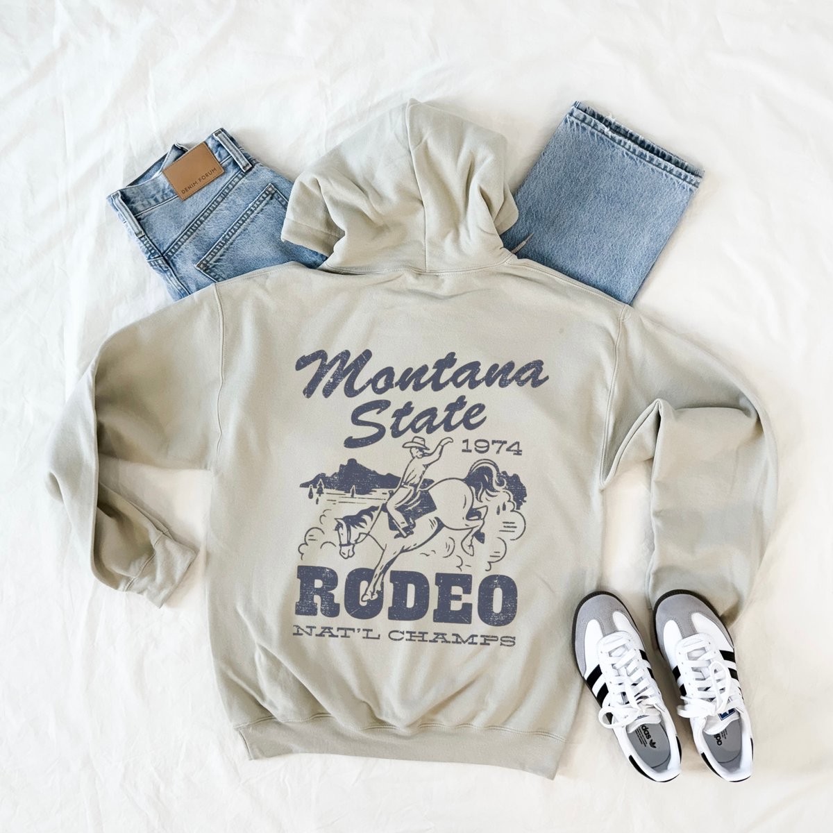 Sand Montana State Rodeo hoodie with oversized distressed cowboy and bucking horse western back graphic.