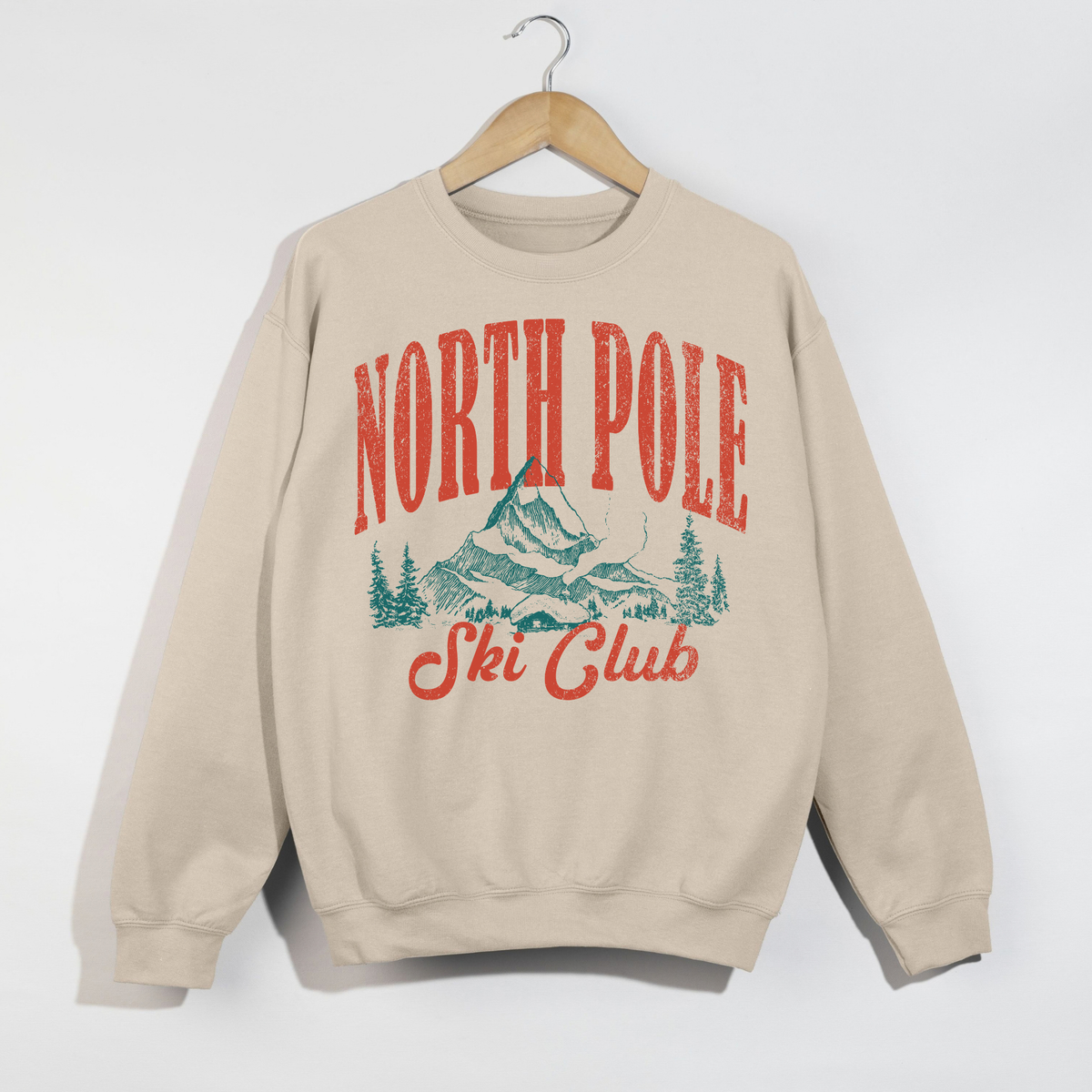 North Pole Ski Club sand sweatshirt with vintage distressed red-orange and teal winter mountain graphic