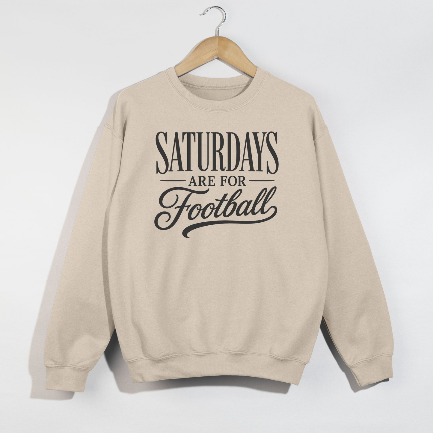 Sand graphic sweatshirt featuring the phrase "Saturdays Are For Football" in vintage black typography on a cozy unisex crewneck.