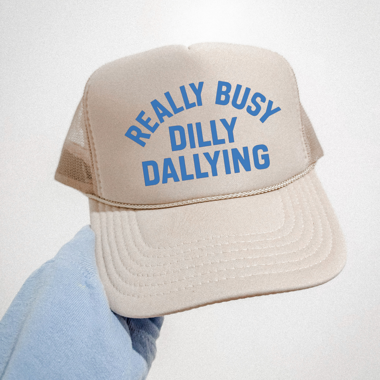 Cream Really Busy Dilly Dallying foam trucker hat with blue lettering on white background