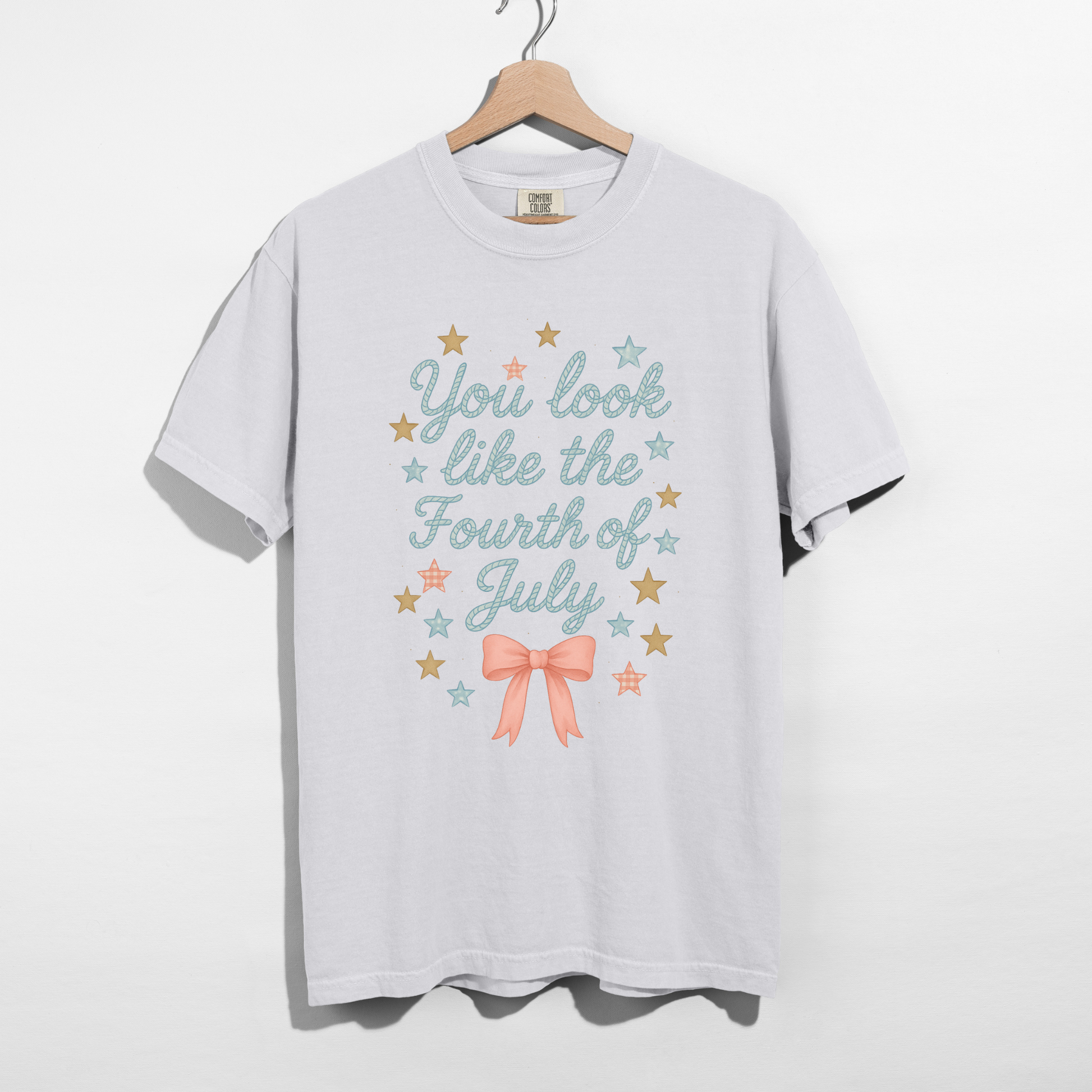 White t-shirt with 'You look like the Fourth of July' text and stars on a hanger against a white background