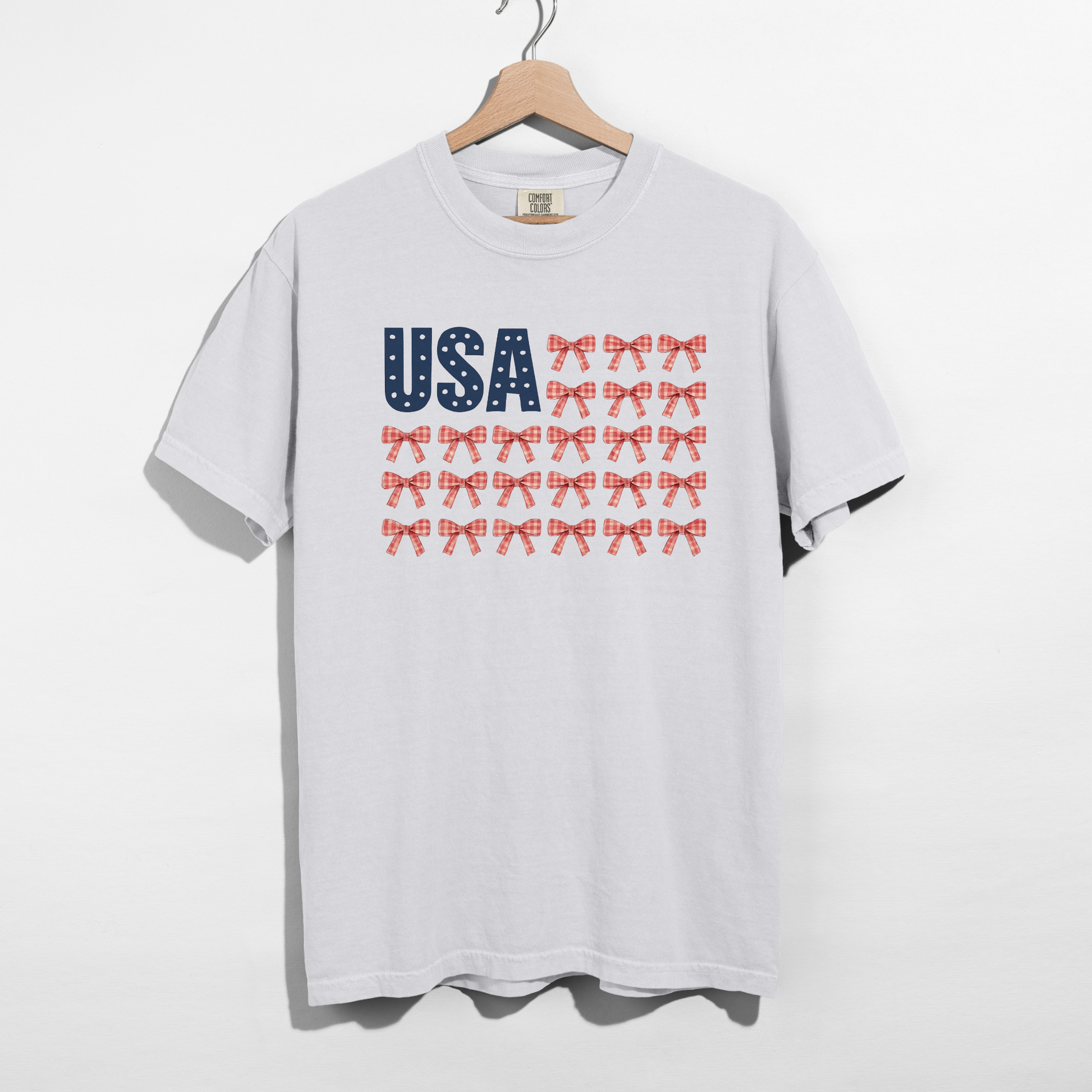 White t-shirt with 'USA' and star patterns on a hanger against a white background