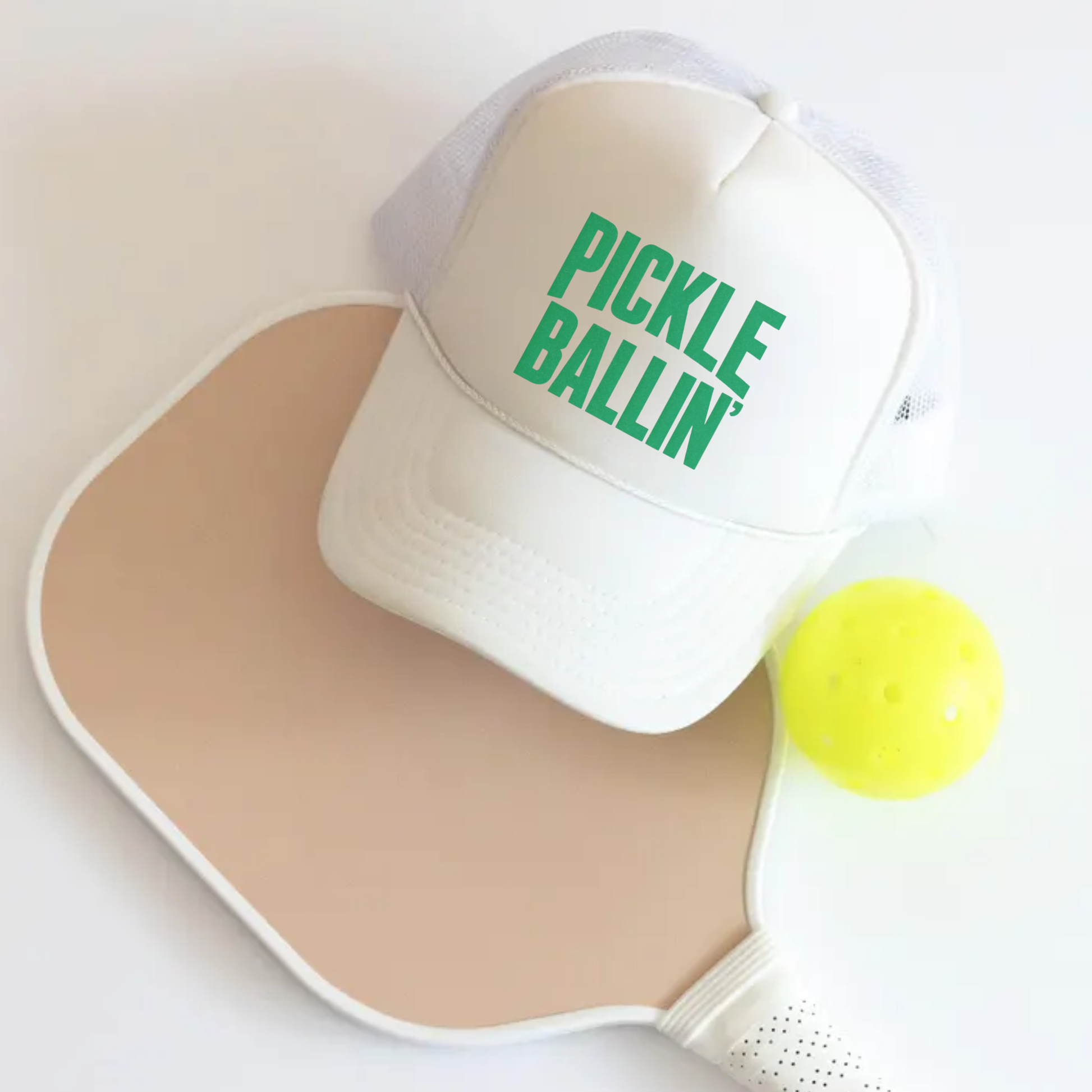 White foam front Otto trucker hat with green “Pickle Ballin’” text styled with pickleball paddle and ball