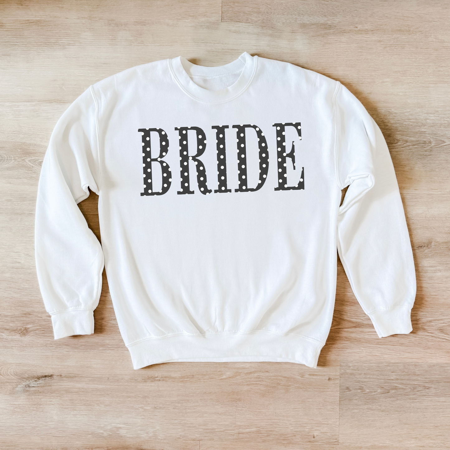 White BRIDE polka dot crewneck sweatshirt flat lay on wood floor