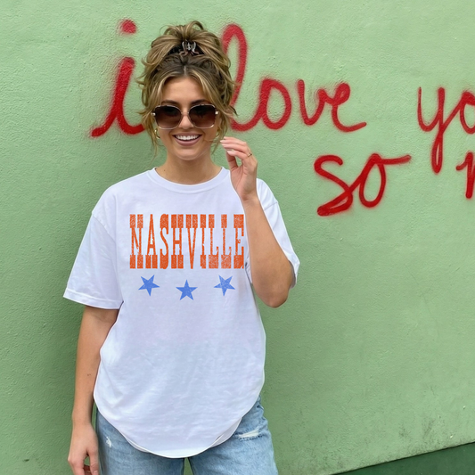 Woman wearing white Nashville graphic t-shirt with stars and distressed lettering casual everyday outfit