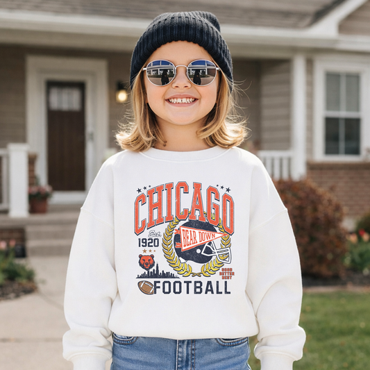 Child wearing white Chicago football crewneck standing in front of Midwest home