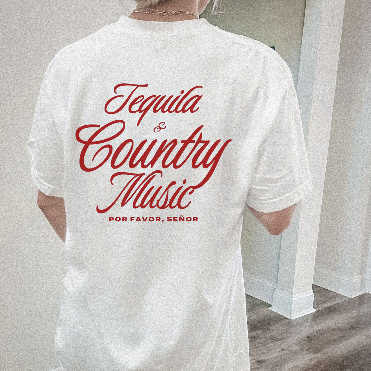 White t-shirt with red text 'Tequila & Country Music Por Favor, Senor' worn by a person indoors.