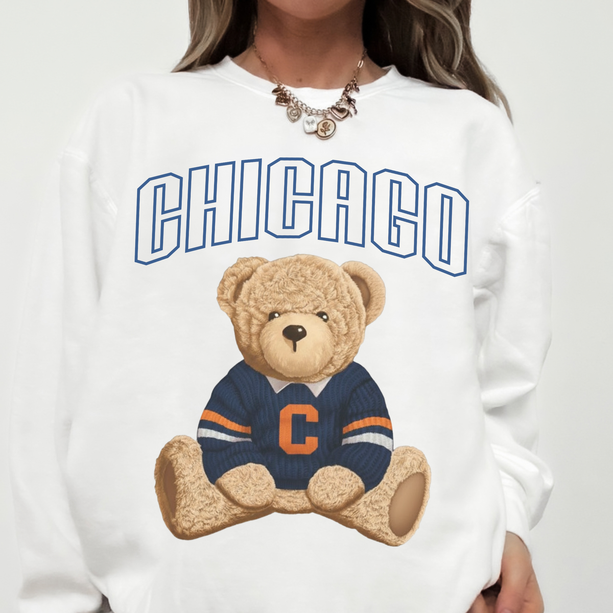 Woman wearing white Chicago retro teddy bear crewneck sweatshirt featuring navy Chicago lettering and football bear