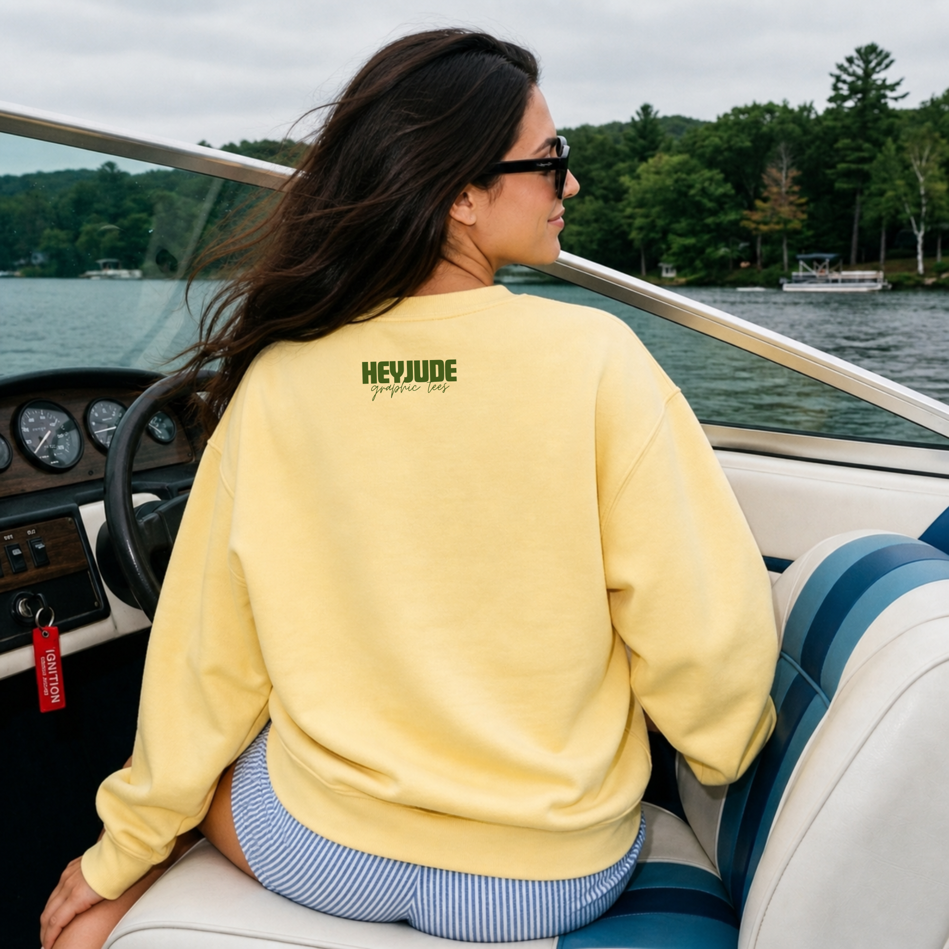 Person wearing a yellow sweatshirt with 'HEVYJUDE' branding on a boat.